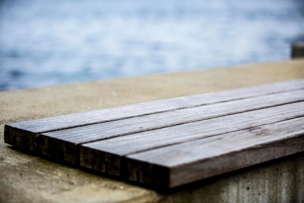 Closeup of a wooden bench on the beach