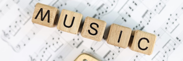 Closeup of wooden cubes with music word on notes art and music composition concept