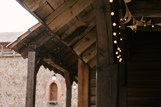 Closeup of a wooden house against the background of a medieval castle and raindrops