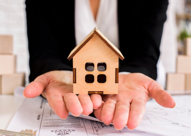 Closeup wooden house on woman hands