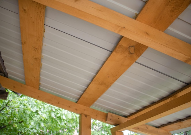 Closeup of wooden roof rafters with metal corrugated board bottom view