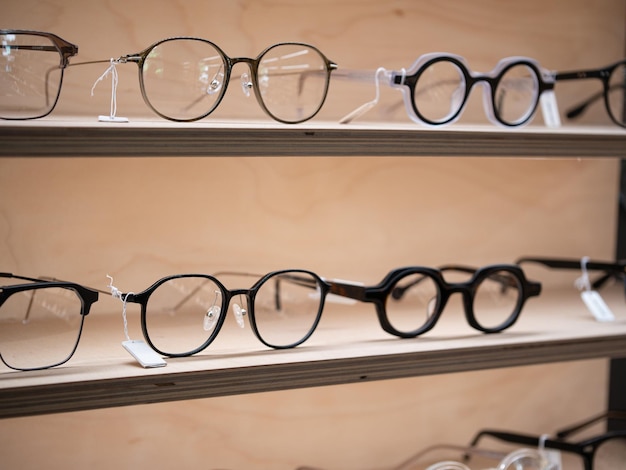 Photo closeup wooden shelves full of modern trendy eyeglasses in optical shop