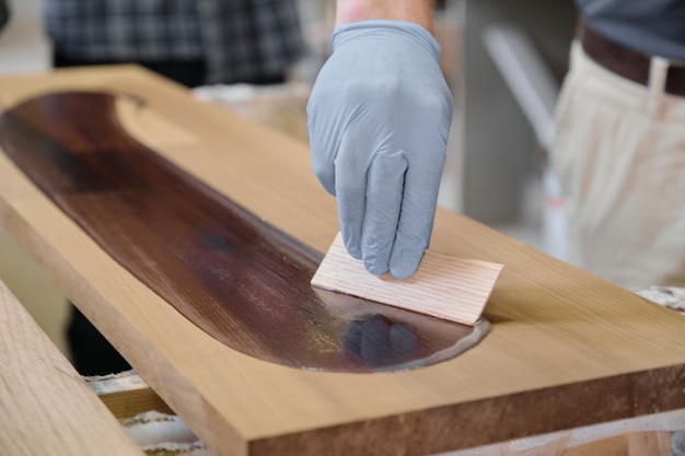 Photo closeup of worker hand in protective gloves with finishing cover