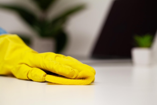 Closeup of worker hand wiping dust in office.