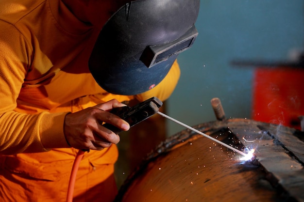 Closeup worker with protective mask welding metal