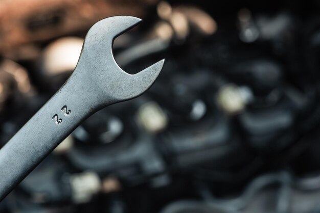 Closeup of a wrench against the background of a car engine Background for an auto store or an auto repair shop