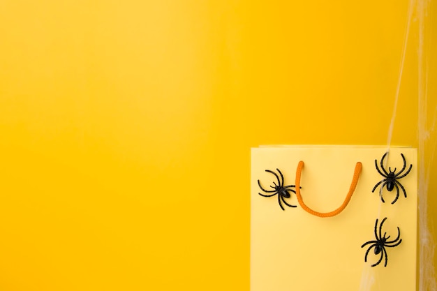 Closeup yellow bag with black spider and cobweb decoration copy space