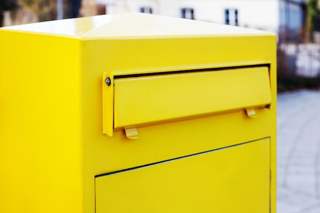 Closeup yellow mailbox for letters and newspapers