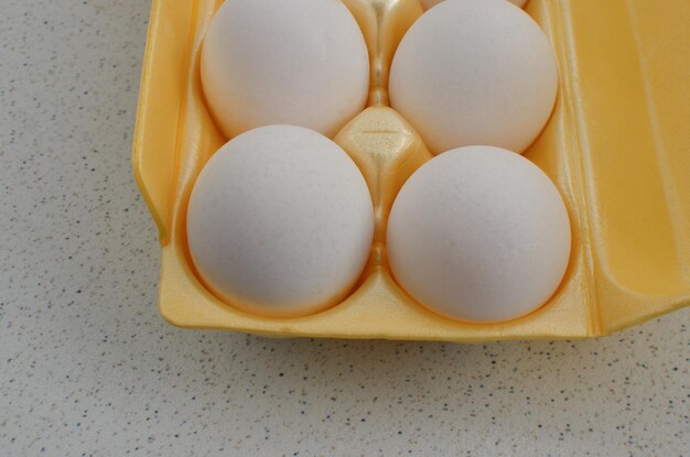 Closeup of yellow packaging with white eggs conveying freshness and purity