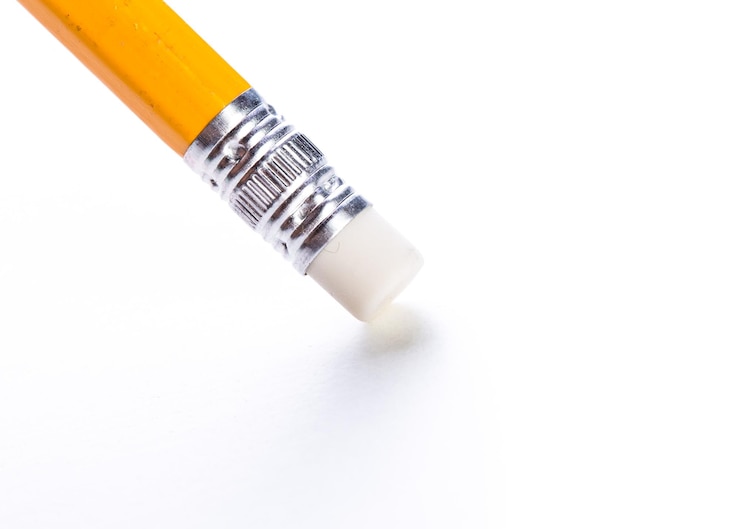 Photo closeup of a yellow pencil with an eraser against a clean white background illuminated by soft light