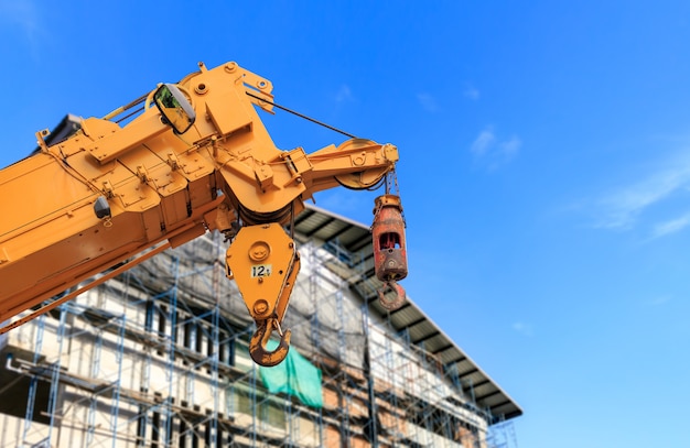 Closeup yellow truck crane, and building construction site 