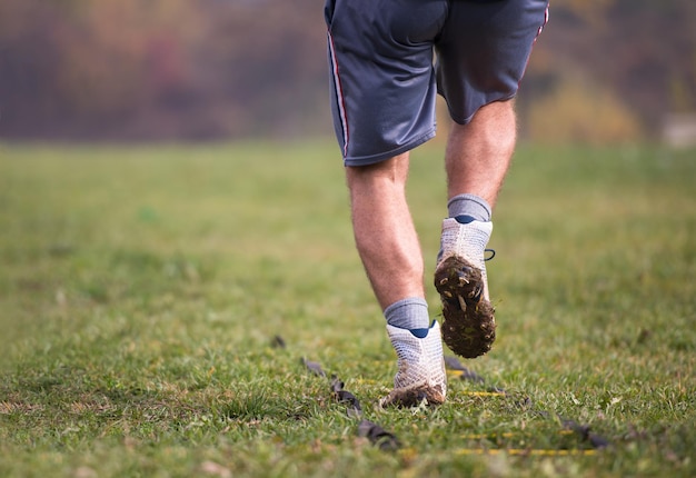 Closeup of young american football player exercises on ladder\
drills at field