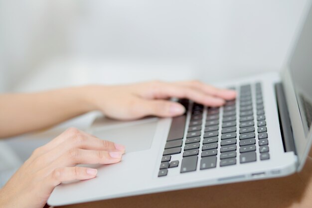 Closeup young asian woman using laptop