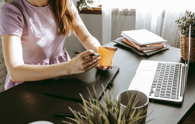 Closeup of young businesswoman working at modern office making notes