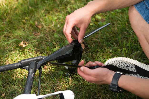 공원에서 수공구로 Uav 드론의 프로펠러를 조이는 젊은 엔지니어의 근접 촬영