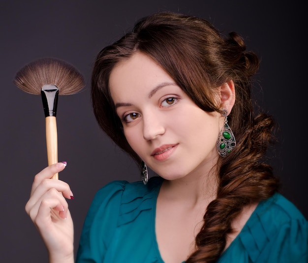 Closeup young girl with makeup brush