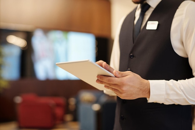 Closeup of young male receptionist using tablet during work