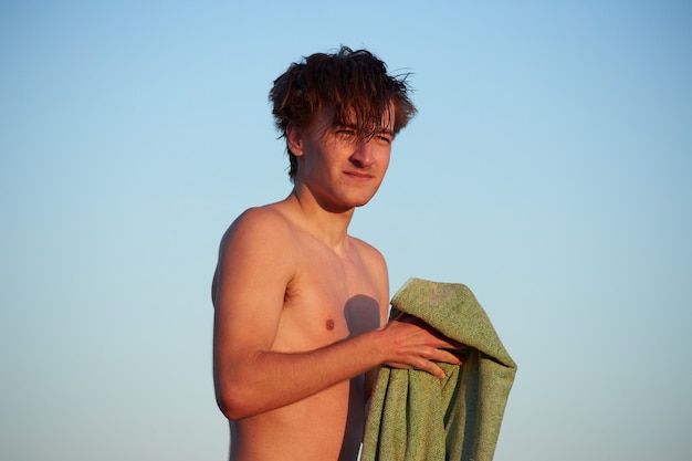 A closeup of the young man holding a towel.