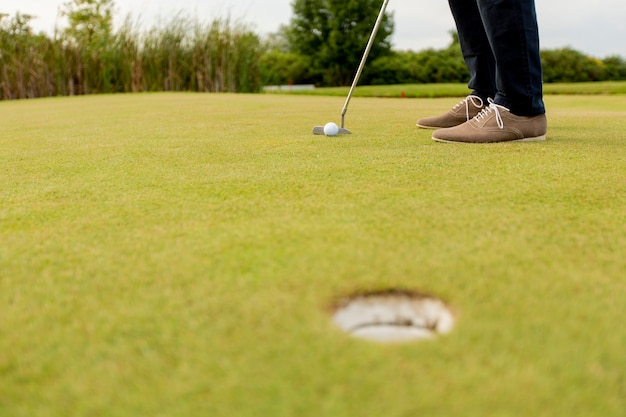 Primo piano delle gambe del giovane che giocano a golf