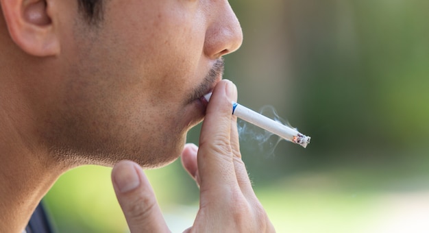 Photo closeup young man smoking a cigarette