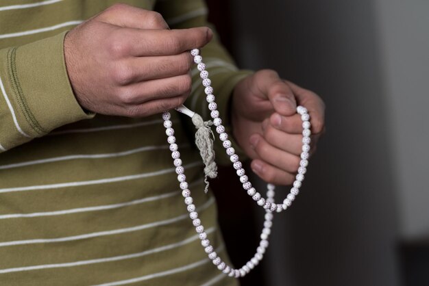 CloseUp Of Young Muslim Man With Rosary Praying In Mosque