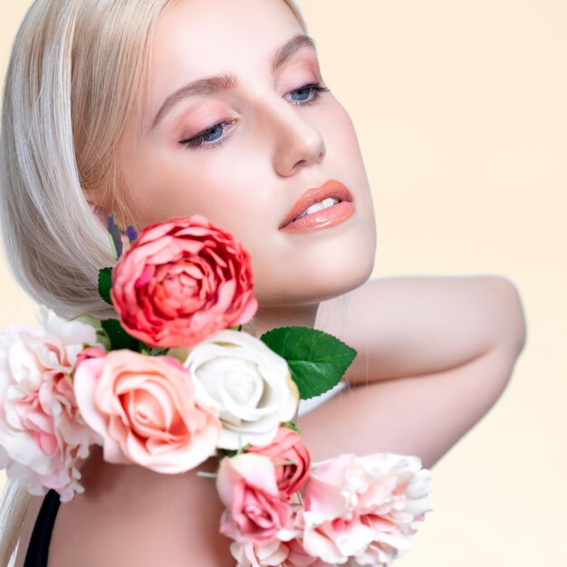 Closeup young personable woman with flawless makeup holding flower
