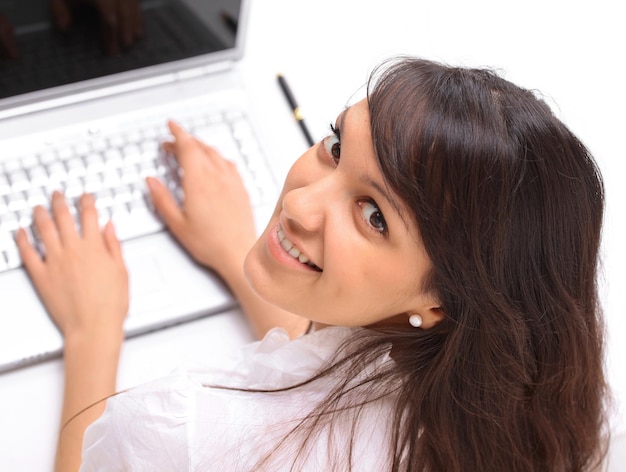 Closeup.young vrouw die op laptop werkt. het uitzicht vanaf de top.isolated op een witte achtergrond