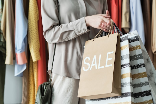 Primo piano della giovane donna che tiene le borse della spesa mentre fa acquisti nel centro commerciale