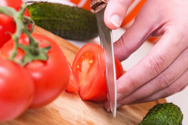 Closeup Of Young Woman In Kitchen Cutting Vegetables