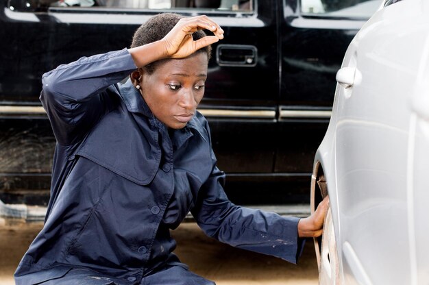 Closeup  of young woman mechanic changing the tire of a car in her garage