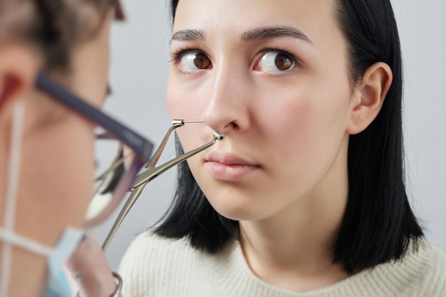 Closeup of a young woman's visage with piercing septum hanging from her nose