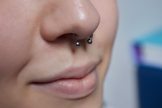 Closeup of a young woman's visage with piercing septum hanging from her nose