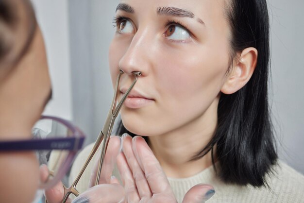 Closeup of a young woman's visage with piercing septum hanging from her nose