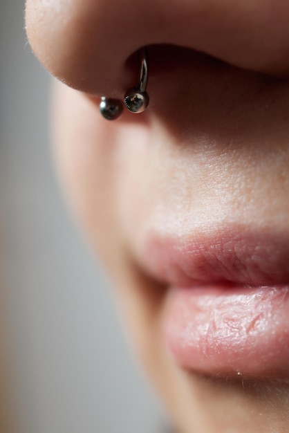 Closeup of a young womans visage with piercing septum hanging from her nose