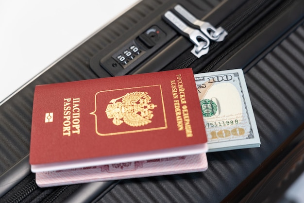 Photo closeup of a zipped suitcase with a passport and money lying on it before a trip