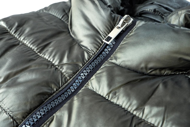 Closeup zipper closure on a light warm olivecolored jacket Warm clothes accessories for outerwear