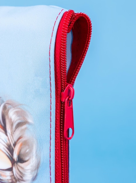 Closeup of a zipper on a pink school pencil case on a blue background Back to school copy space