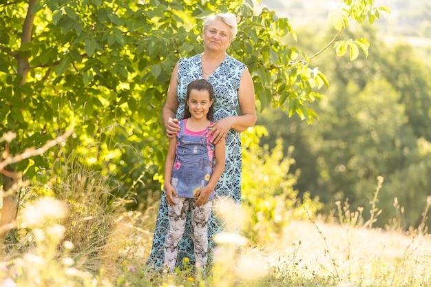 Closeup zomer portret van gelukkige grootmoeder met kleindochter buitenshuis.