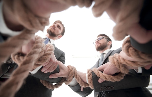 Команда Closeupbusiness держит крепкую веревку