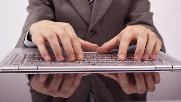 Closeupbusinessman typing on laptop keyboard isolated on a white background