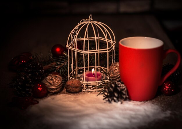 Closeupred cup and candle at the christmas holiday table