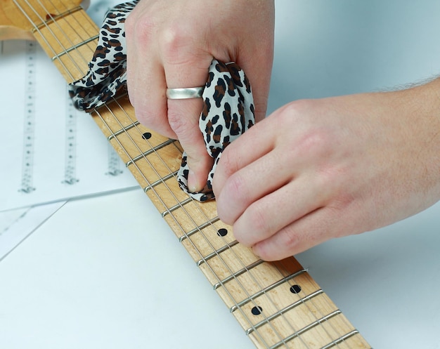 Photo closeuprock guitaristwiping the neck of the guitar