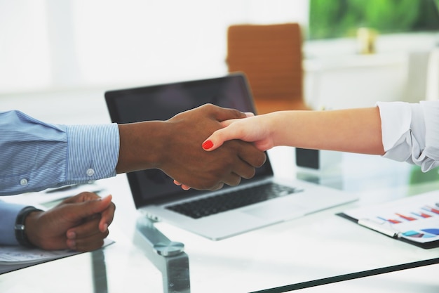 Closeupstrong financial partners shaking hands over a Desk