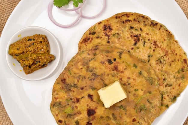 Photo closuep of methi paratha with butter slice and pickle