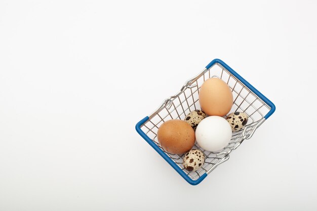 흰색 배경에 고립 된 쇼핑 트롤리에 근접 촬영 갈색과 흰색 닭고기 달걀