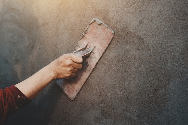 Closup hand of workers plastering on wall outdoor at construction site