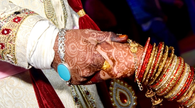 Closup of Indian Young adult male groom and female bride holding hands