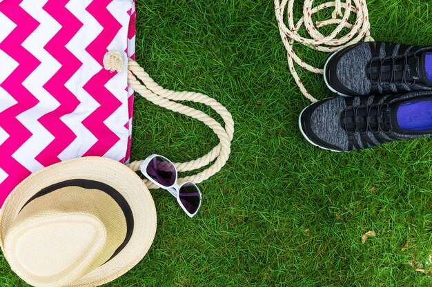 Cloth bags and hats on the grass.