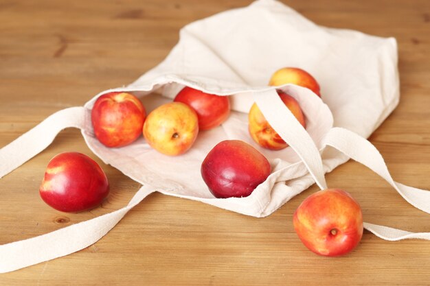 Cloth shopping bag, fabric bag with peaches on the table