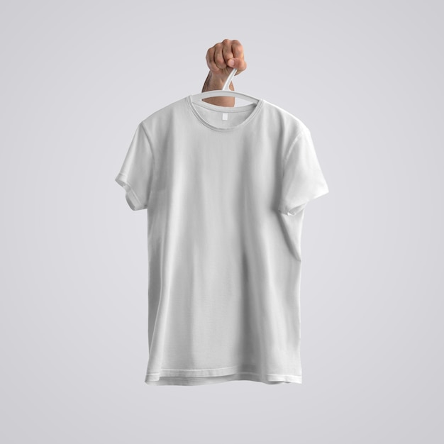 Cloth template. A blank T-shirt with shadows on a plastic hanger with hand  on a white background.  Front position. Mockup ready to use in your design